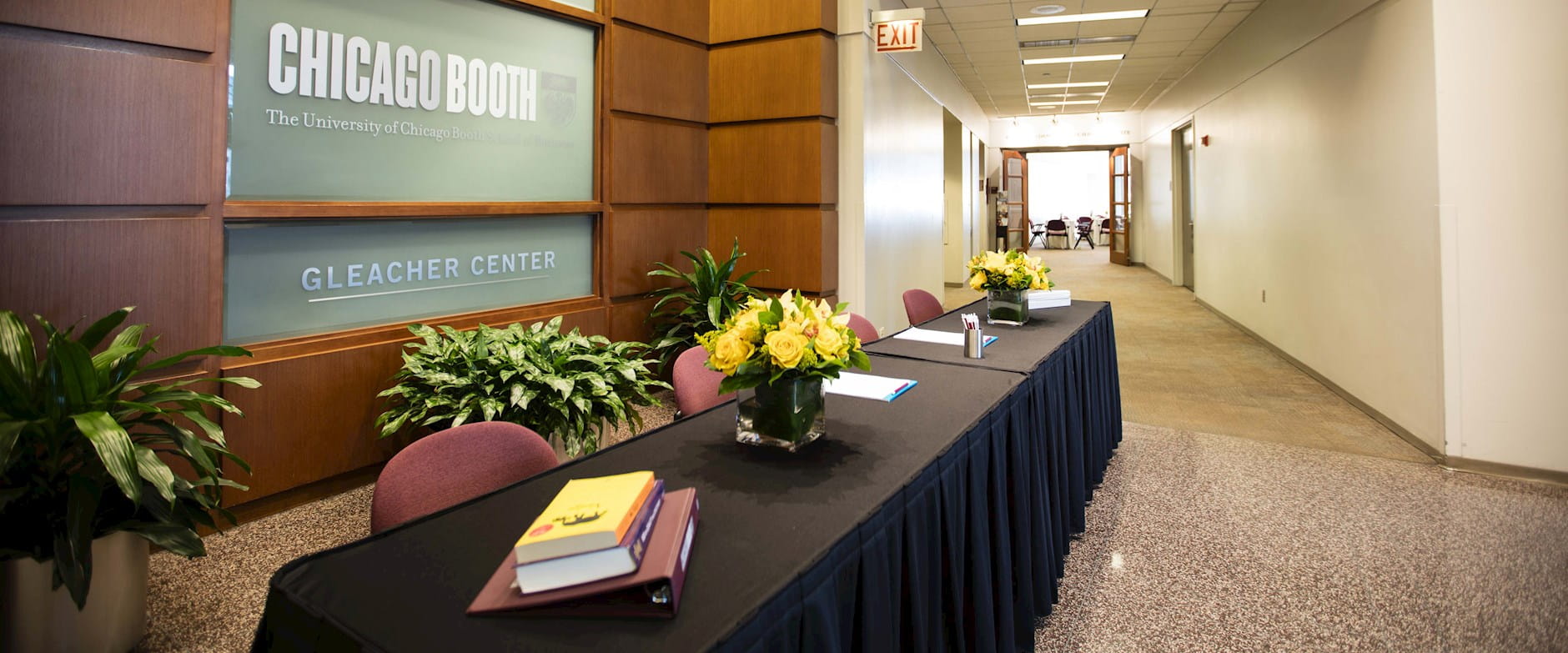 The University of Chicago Booth School of Business Gleacher Center's main floor hallway decorated with yellow flower bouquets 