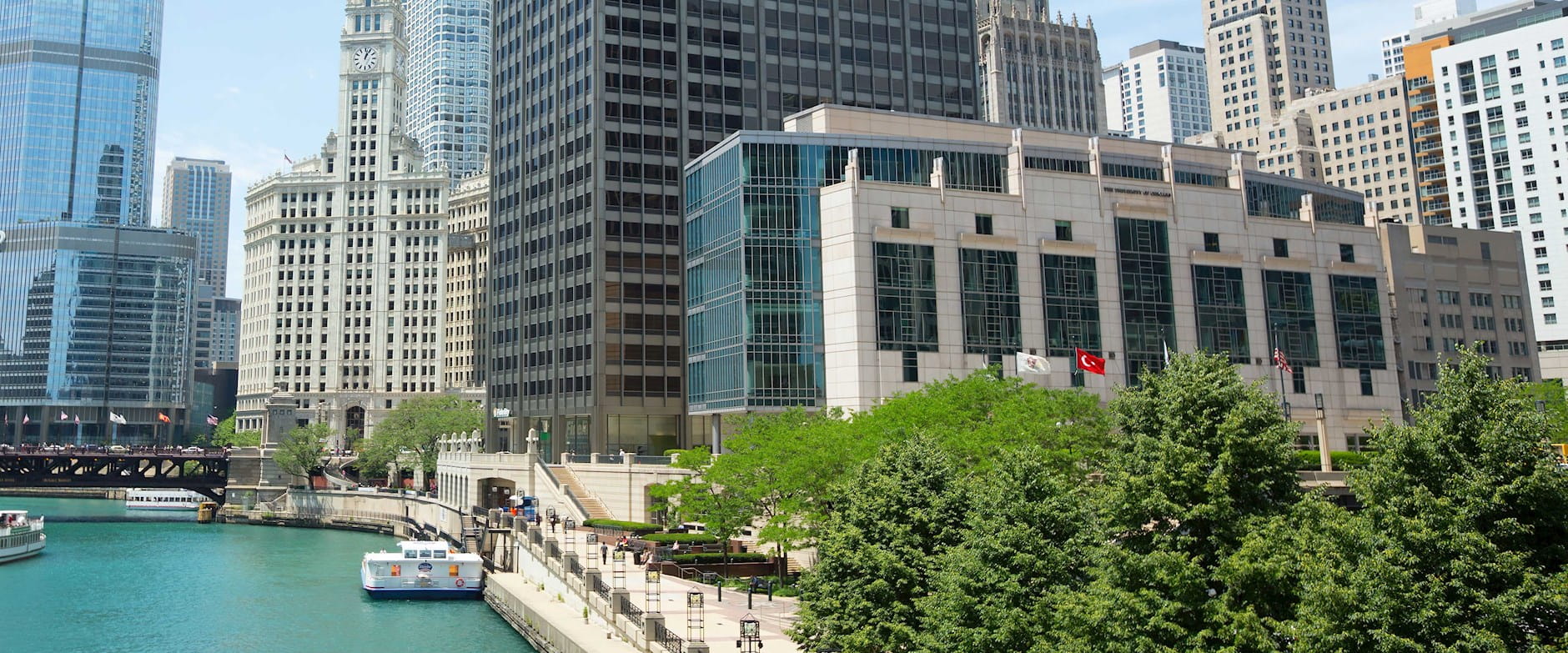 The Gleacher Center with the Chicago River to the side on a sunny day