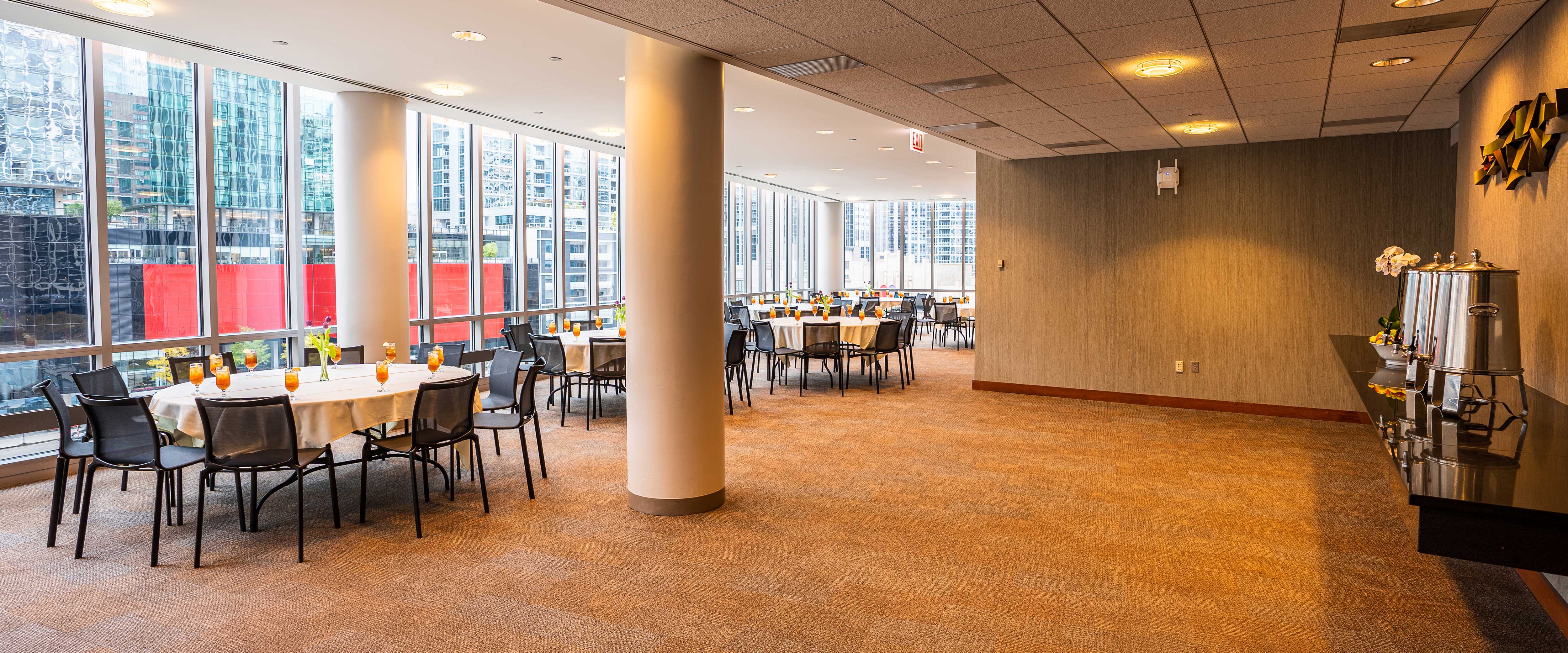 View of the Medium North Lounge at the Gleacher Center with a wide open space with tables along a window on the side