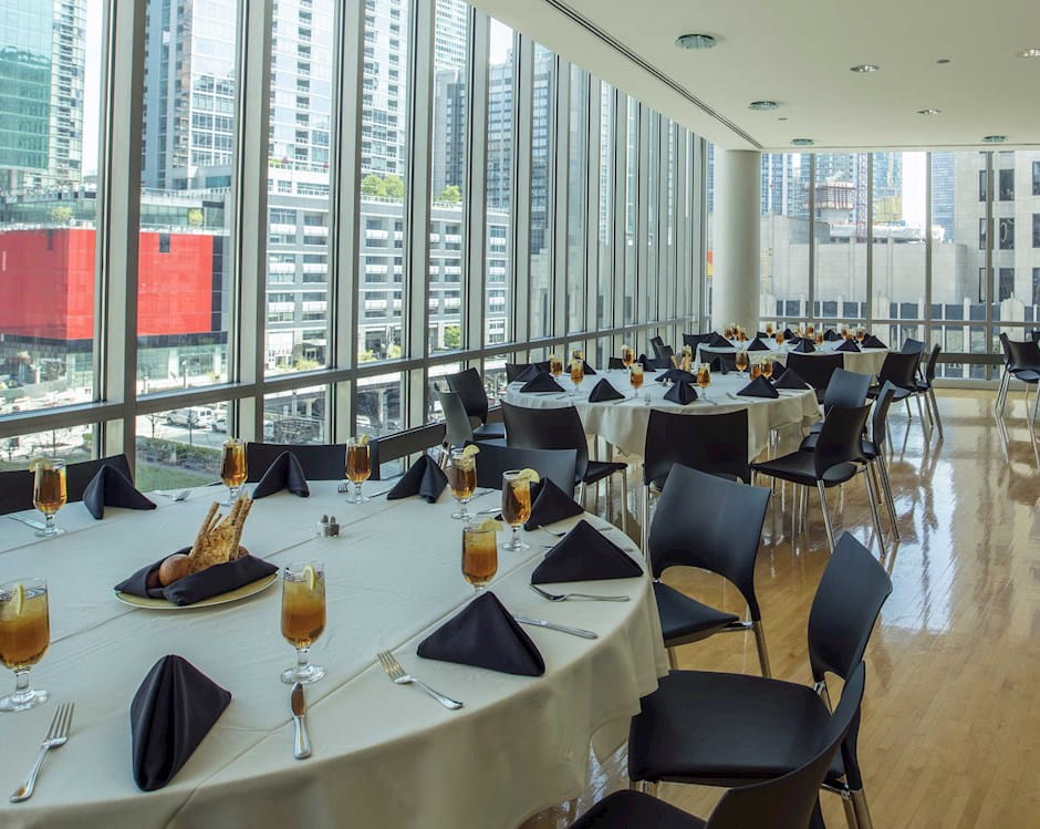 Looking out over the plaza from a small dining room in Gleacher Center with circular tables surrounded by chairs