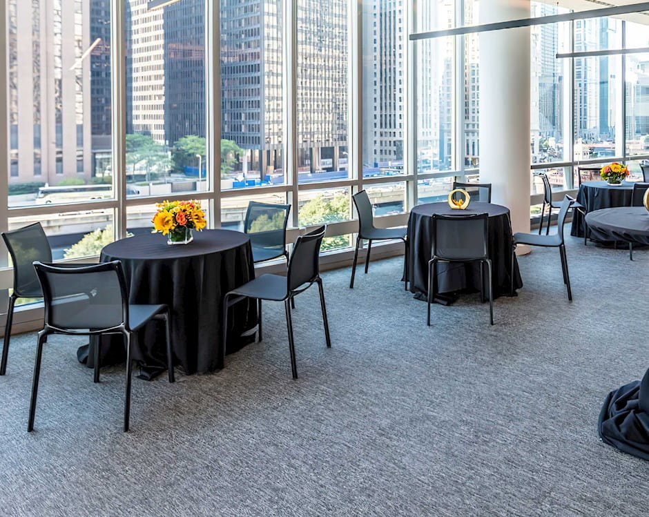Veranda of the PIMCO Midway Club in Gleacher Center with brightly lit tables and floor to ceiling windows