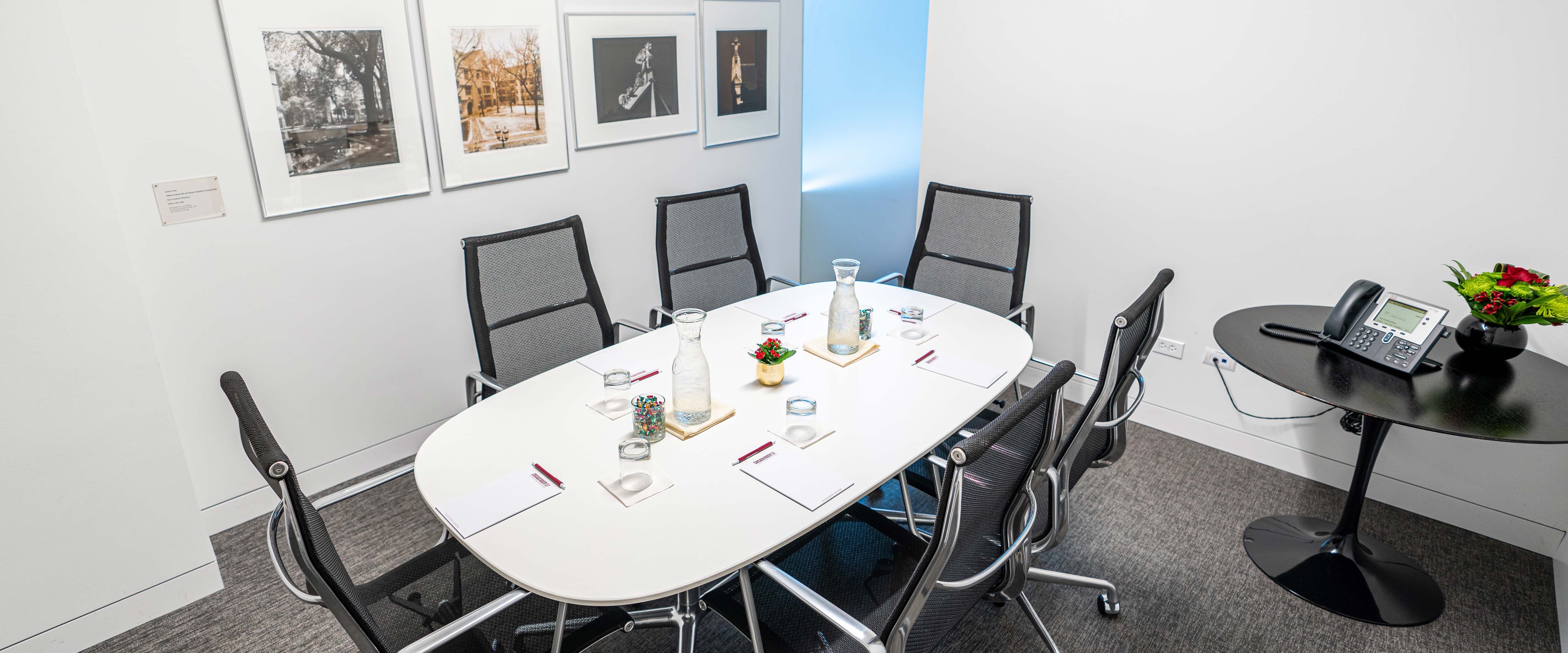 Small boardroom with a six-person table set with notepads