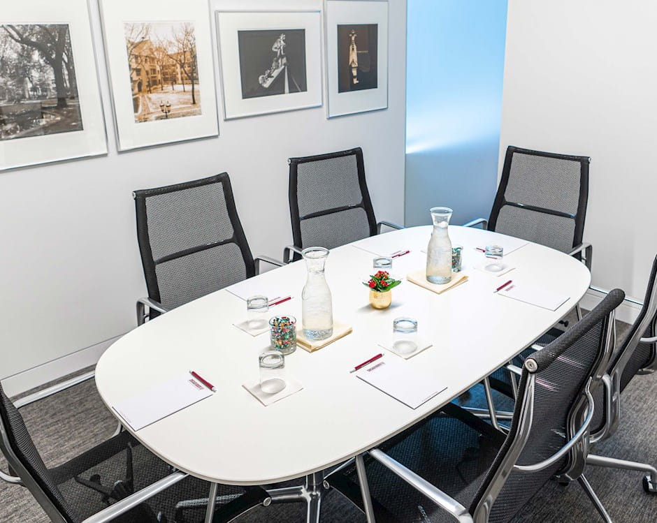 Small boardroom with a six-person table set with notepads