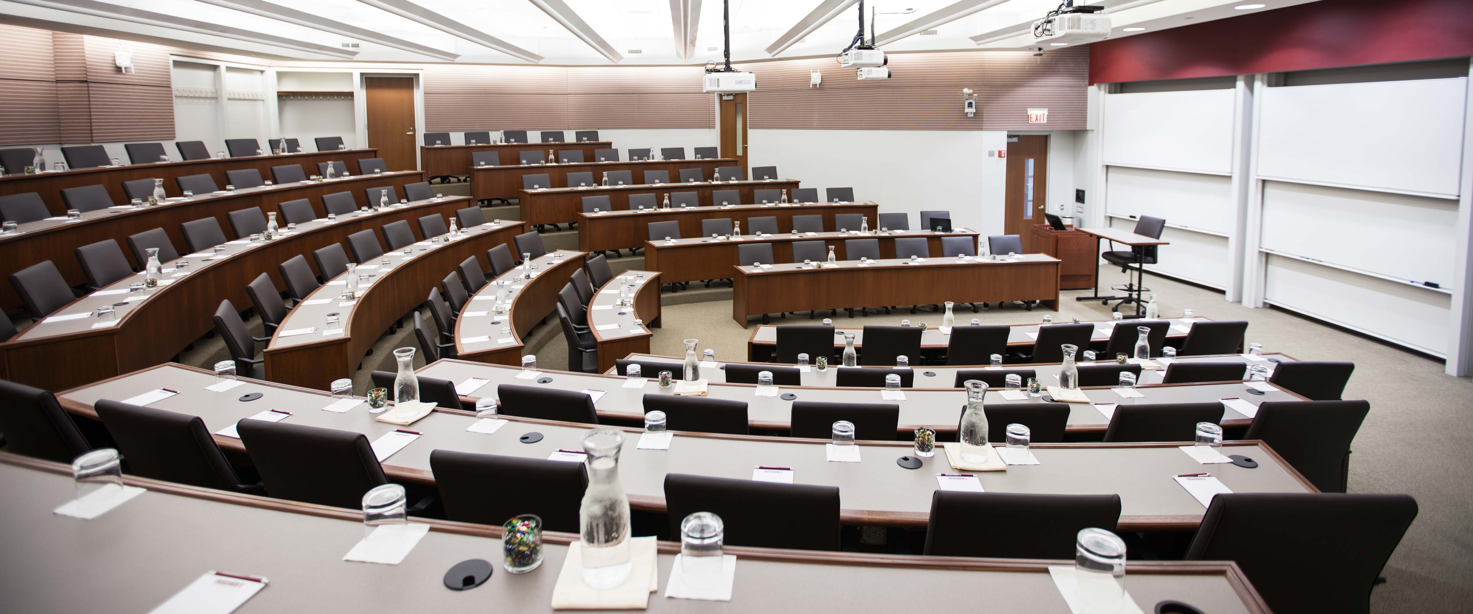 Gleacher Center room 100 from the back of the right side looking down at tiered tables and chairs