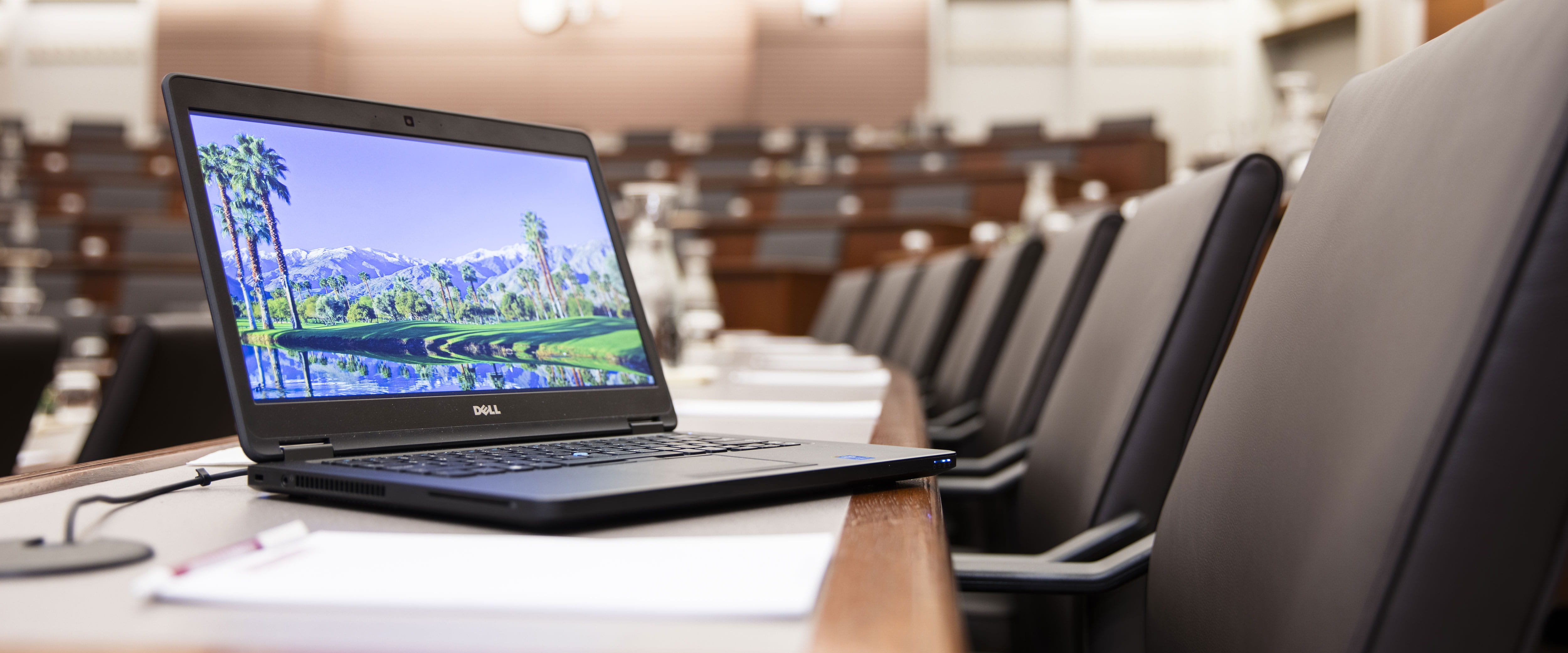 An open laptop on a table in room 100 at the University of Chicago Gleacher Center