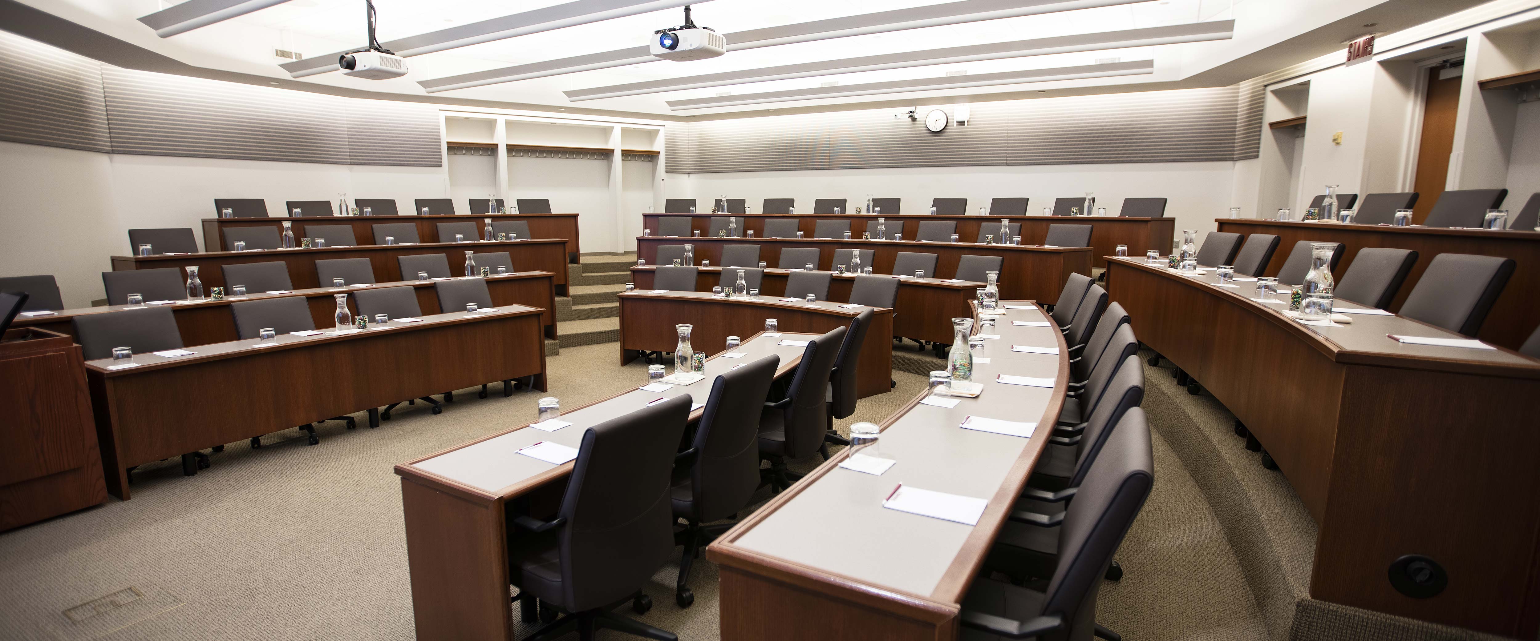 A wide view from the left of the Gleacher Center room 406 showing tiers of tables and chairs in a semi-circle